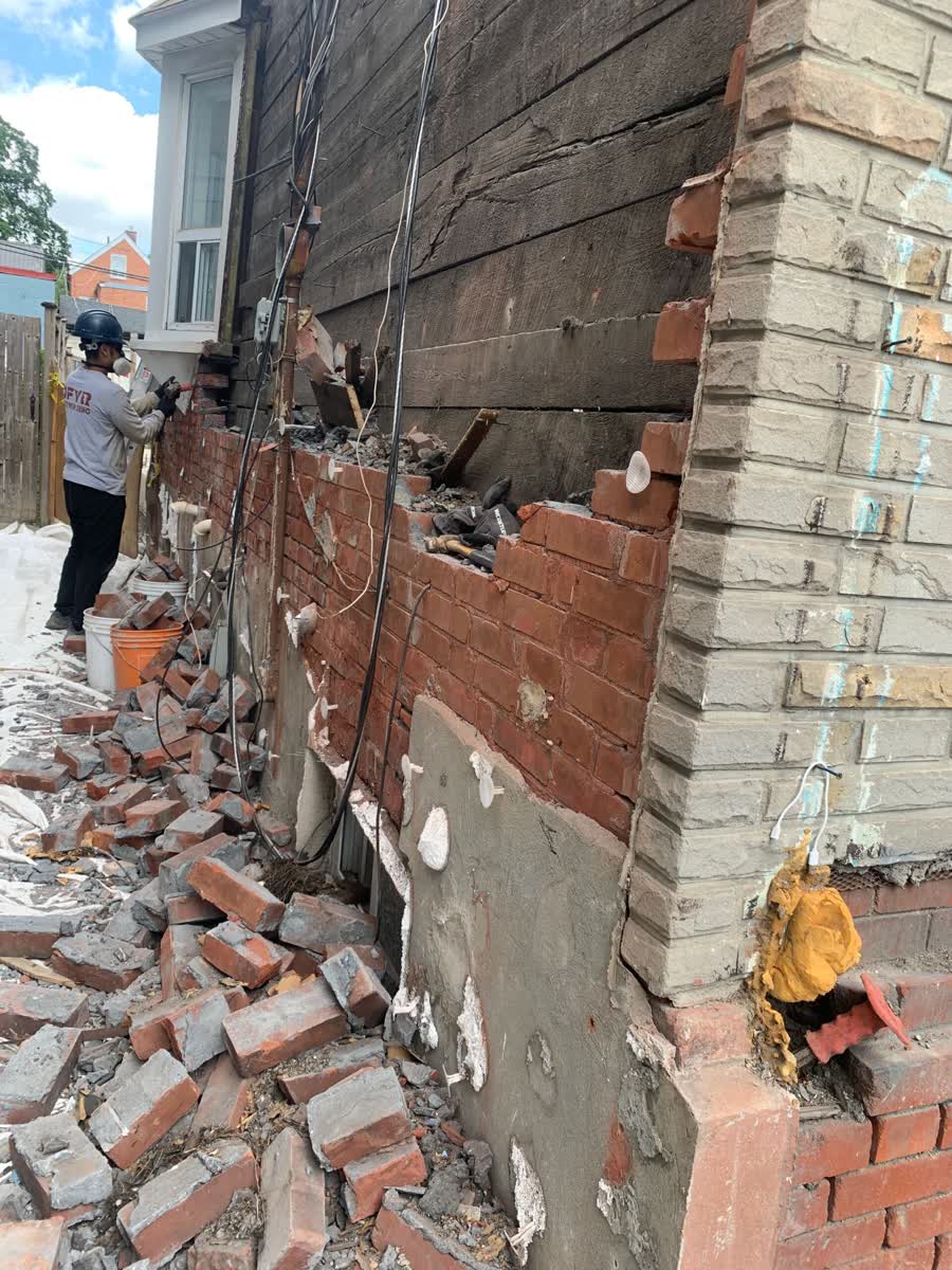 DFYR crew member in company shirt removing brick by hand