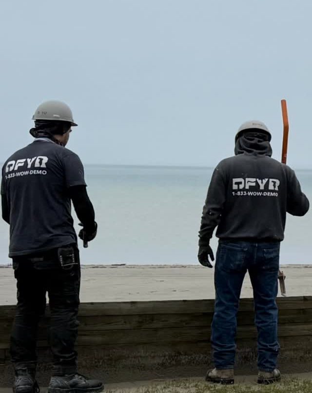 Two DFYR crew members in branded gear working on a shoreline timber job