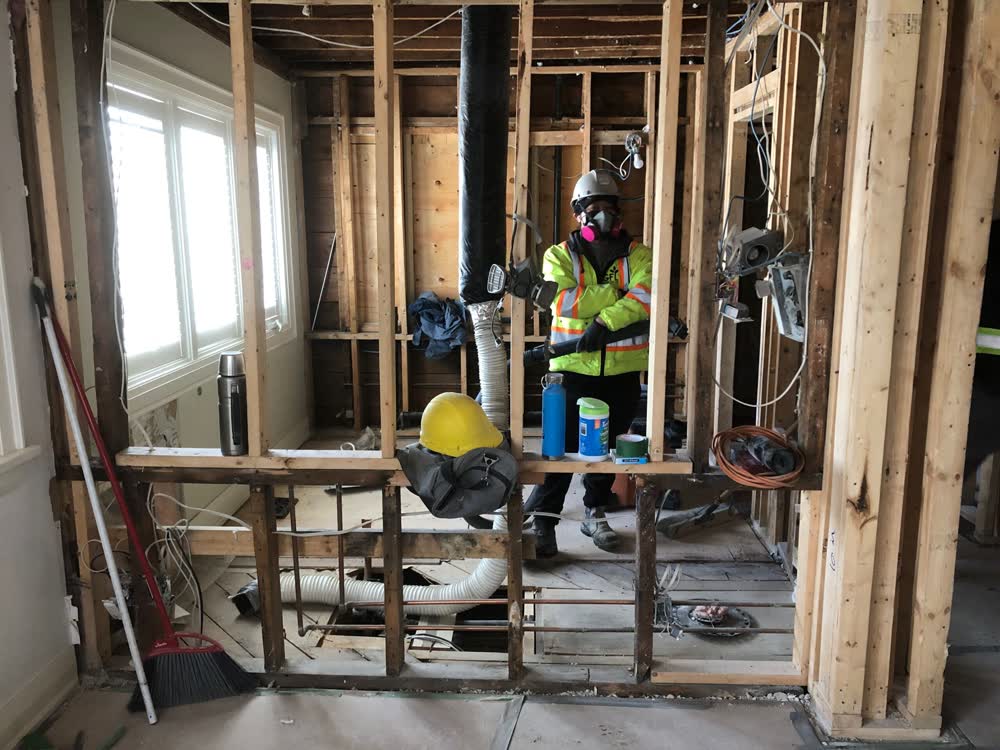 DFYR crew member in respirator and hi-vis inside a stripped room