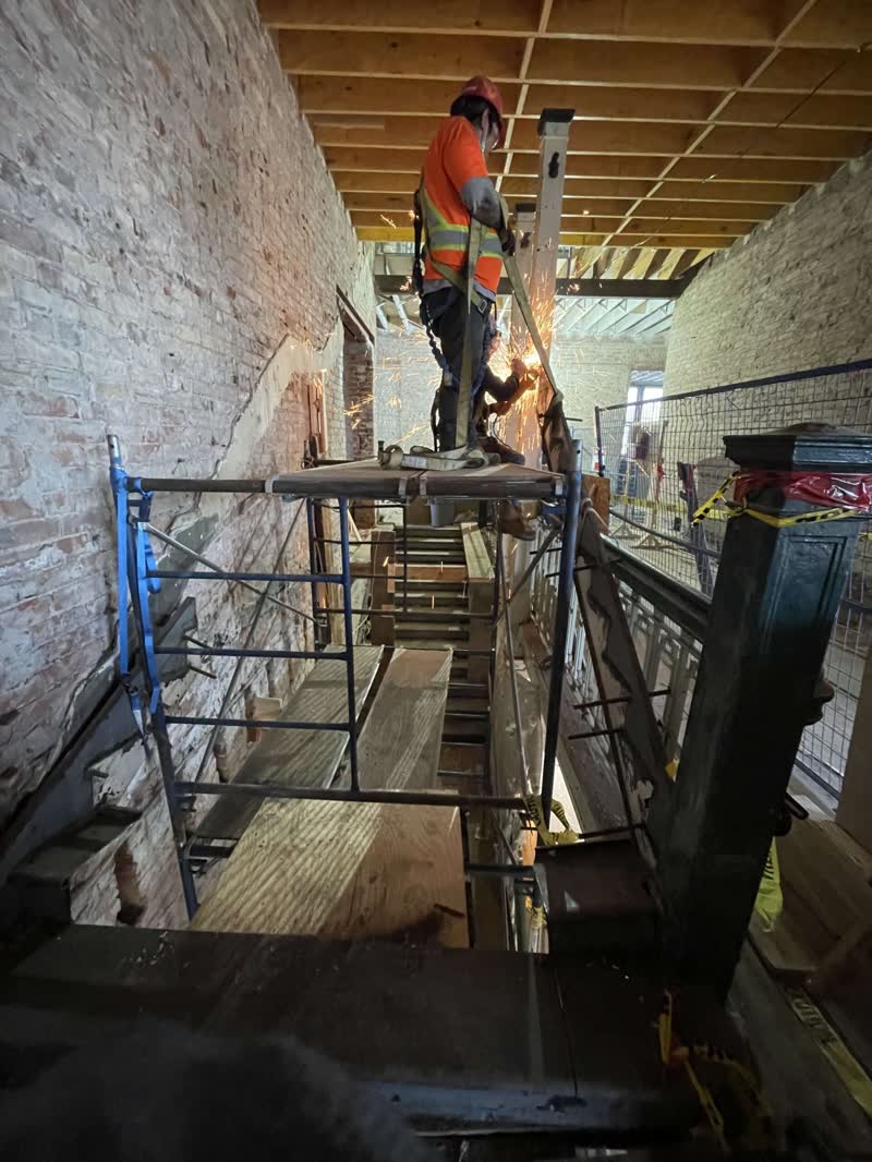 DFYR crew member cutting steel beside a preserved staircase